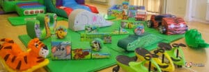 Play area with a jungle theme, featuring a slide and various toys, creating an adventurous space for kids to play.