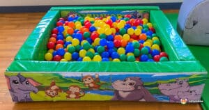 A large jungle-themed soft play area featuring a colorful ball pit filled with numerous balls for children to enjoy.