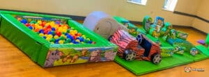 A jungle-themed soft play area showcasing an assortment of toys and furniture, inviting children to engage in imaginative play.