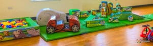 A vibrant jungle-themed soft play area featuring various toys and furniture for children to explore and enjoy.