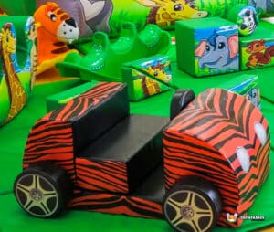 A vibrant jungle-themed soft play area featuring various toys and furniture for children to explore and enjoy.