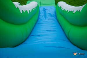 A large inflatable slide, the Mammoth slide, showcases a striking green and white design, inviting children to play.