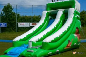 Mammoth slide: a large inflatable slide with a bright green and white design, perfect for outdoor summer fun.