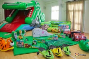 Large inflatable jungle-themed play area featuring animal designs, including a crocodile slide and soft play elements