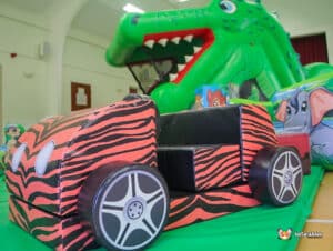 Vibrant inflatable jungle play area with animal designs, including a crocodile slide and matching soft play features.