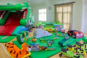 Colorful inflatable jungle-themed play area with animal figures, featuring a crocodile slide and soft play components.