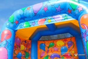 A cheerful bouncy castle featuring balloon decorations, creating a festive atmosphere for kids' parties and events.