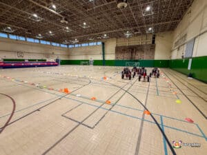 A collection of go-karts arranged in a gymnasium, highlighting their bright colors and racing potential.