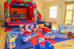 Pirate-themed bouncy castle featuring colorful toys, designed for fun and soft play activities for children.