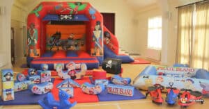 . A colorful bouncy castle with pirate decorations and toys, providing a fun soft play experience for children.