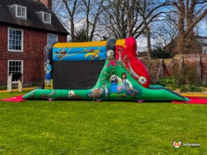 A colorful inflatable pirate-themed bounce house set on a green lawn, featuring vibrant artwork of pirates and treasure.