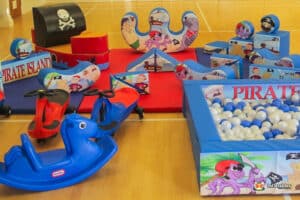 A vibrant pirate-themed play area featuring soft toys and structures for children to climb and explore.