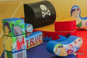 A vibrant play shape, shaped like a pirate ship, laid out on the floor, ideal for children's soft play and imaginative games.