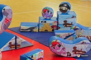 A cheerful pirate-themed play area with soft toys and climbing structures, designed for children's fun and exploration.