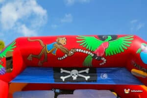 A playful inflatable pirate ship showcasing a pirate flag and a parrot, suitable for children's parties.