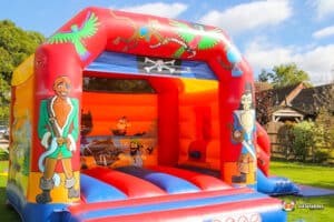 A playful pirate-themed bouncy castle, adorned with colorful sails and skull designs, ready for kids to jump and have fun.