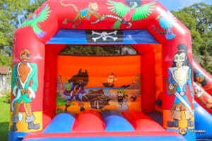 A vibrant bouncy castle designed with a pirate theme, showcasing sails and pirate motifs, perfect for children's entertainment.