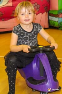young girl playing on plasma car