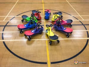 A set of colorful scooters on the floor, designed for kids to ride, highlighting a variety of cheerful colors.
