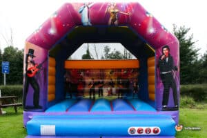 A vibrant inflatable bouncy castle featuring colorful graphics of musicians, perfect for children's parties and entertainment.