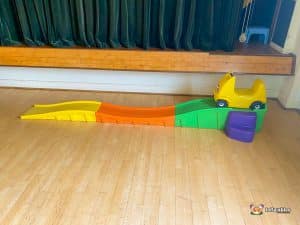 A colorful slide with a toy car on top, symbolizing fun and adventure in a playful atmosphere.