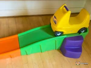 A vibrant slide with a toy car at the top, inviting children to enjoy a playful ride in a lively environment.