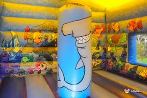 A whimsical inflatable shark with a cartoon design, showcasing vibrant colors and a friendly expression, ready for fun.