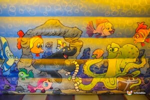A large, colorful inflatable adorned with cartoon characters and fish, designed to entertain and delight children.