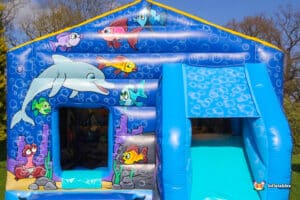 A vibrant bouncy castle decorated with dolphins and fish, inviting children to play and jump joyfully.