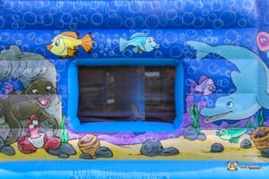 A colorful bouncy castle featuring an underwater theme, adorned with sea creatures and vibrant ocean colors.
