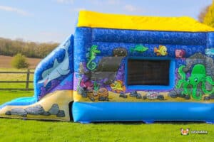 Underwater-themed inflatable bouncer adorned with vibrant sea life and a bright blue ocean design.