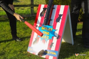 A playful red and white striped sign displaying a mouse, titled "Splat The Rat."