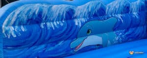A vibrant inflatable with ocean waves and a cheerful dolphin design, perfect for water-themed fun and entertainment.