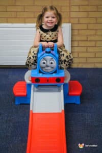 Thomas the Train ride at a children's party, with kids excitedly enjoying the ride in a festive atmosphere.
