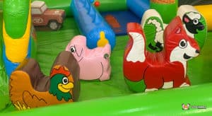 A vibrant inflatable play area filled with animal figures and assorted toys, designed for children's entertainment and fun.