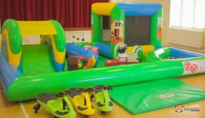 A vibrant toddler play area with a bouncy castle, slide, and assorted toys designed for young children's fun and play.