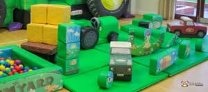 A vibrant play area featuring various toys, including a B&S Deluxe Package tractor for children to enjoy.