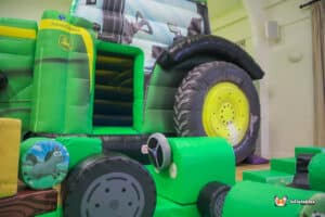 A children's play area equipped with toys, highlighted by a B&S Deluxe Package tractor for imaginative play.