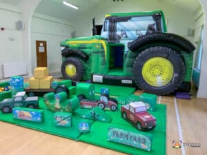 Inflatable tractor with toys and a play area, part of the Tractor Deluxe Package, providing fun for children.