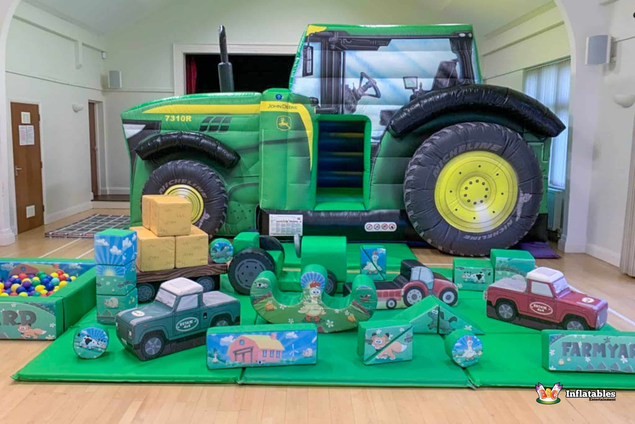 Large inflatable tractor with a play area and toys, featured in the Tractor B&S Deluxe Package for children's enjoyment.