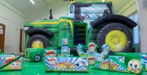 Vibrant play area showcasing the Tractor Bounce & Slide Soft Play Package, complete with toys and a bouncy tractor.