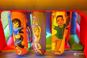 Colorful inflatable columns featuring playful cartoon characters in a vibrant bouncy castle setting.