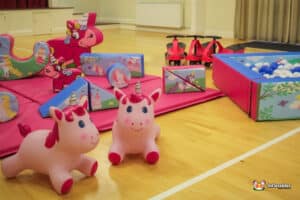 Bright play area showcasing toys, a ball pit, and a playful unicorn, inviting children to explore and enjoy.