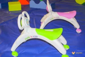 A vibrant toy featuring wheels and a seat, made for children to enjoy walking and riding experiences.