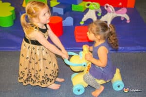 Children playing on small ride on toy.