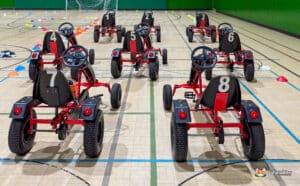 A collection of red and black go-karts positioned on a track, awaiting drivers for a thrilling competition.
