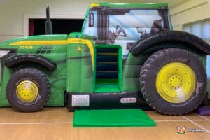 A giant inflatable tractor equipped with a slide, creating an engaging play experience for children at festivals or parties.