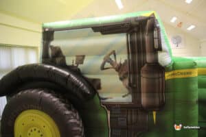 A large inflatable tractor displaying a graphic of a tractor, intended for entertainment or promotional purposes.
