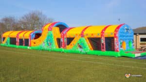 inflatable obstacle course displayed on a grassy field, inviting participants to enjoy outdoor fun.