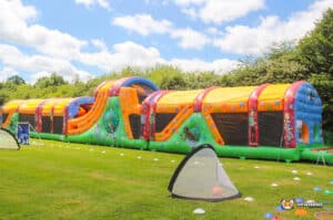A vibrant giant inflatable obstacle course situated on a grassy field, ready for adventure.